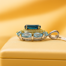 Side view of the aquamarine and London blue topaz necklace on a creamy jewelry display 