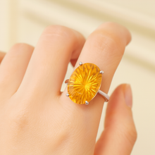 Hand model wearing Curación Holistica citrine ring against a neutral backdrop.”