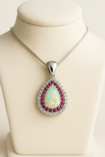 “Elegant sterling silver opal and ruby halo necklace handmade by Curación Holística, featuring a luminous teardrop fire opal.”