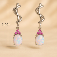 “Elegant sterling silver earrings with white opal center and ruby accents”
