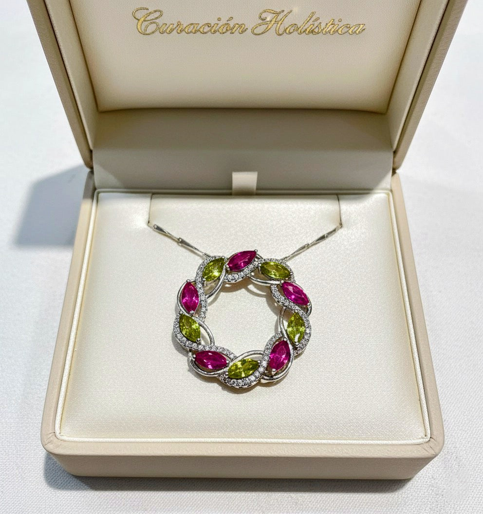 Jewelry box with a silver necklace featuring pink and green gemstones on a white background.