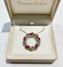 Jewelry box with a silver necklace featuring pink and green gemstones on a white background.