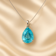 	Teardrop aquamarine necklace on cream satin display with soft lighting