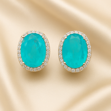 Close-up of luminous oval Paraiba tourmaline earrings in sterling silver