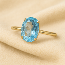 Aquamarine ring worn on a model’s hand with boho outfit styling