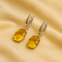 Sterling silver earrings featuring vibrant oval-cut citrines
