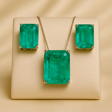 Earrings and necklace set shown flat lay on luxury satin