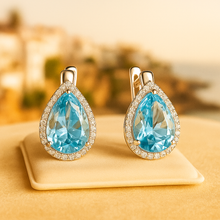 Jewelry box with earrings against Mediterranean-inspired fabric backdro