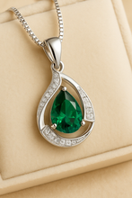 Branded packaging of Curación Holística with the emerald necklace inside