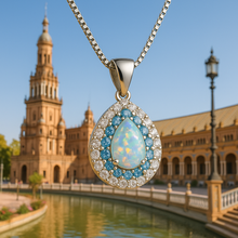“Luxury artisan necklace featuring a luminous white opal framed by small aquamarine stones, exclusive to Curación Holística.”