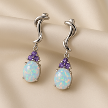 “Exclusive handmade sterling silver earrings with natural opal and amethyst stones by Curación Holística.”