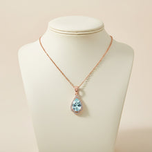 Necklace with a blue teardrop pendant on a mannequin bust against a beige background